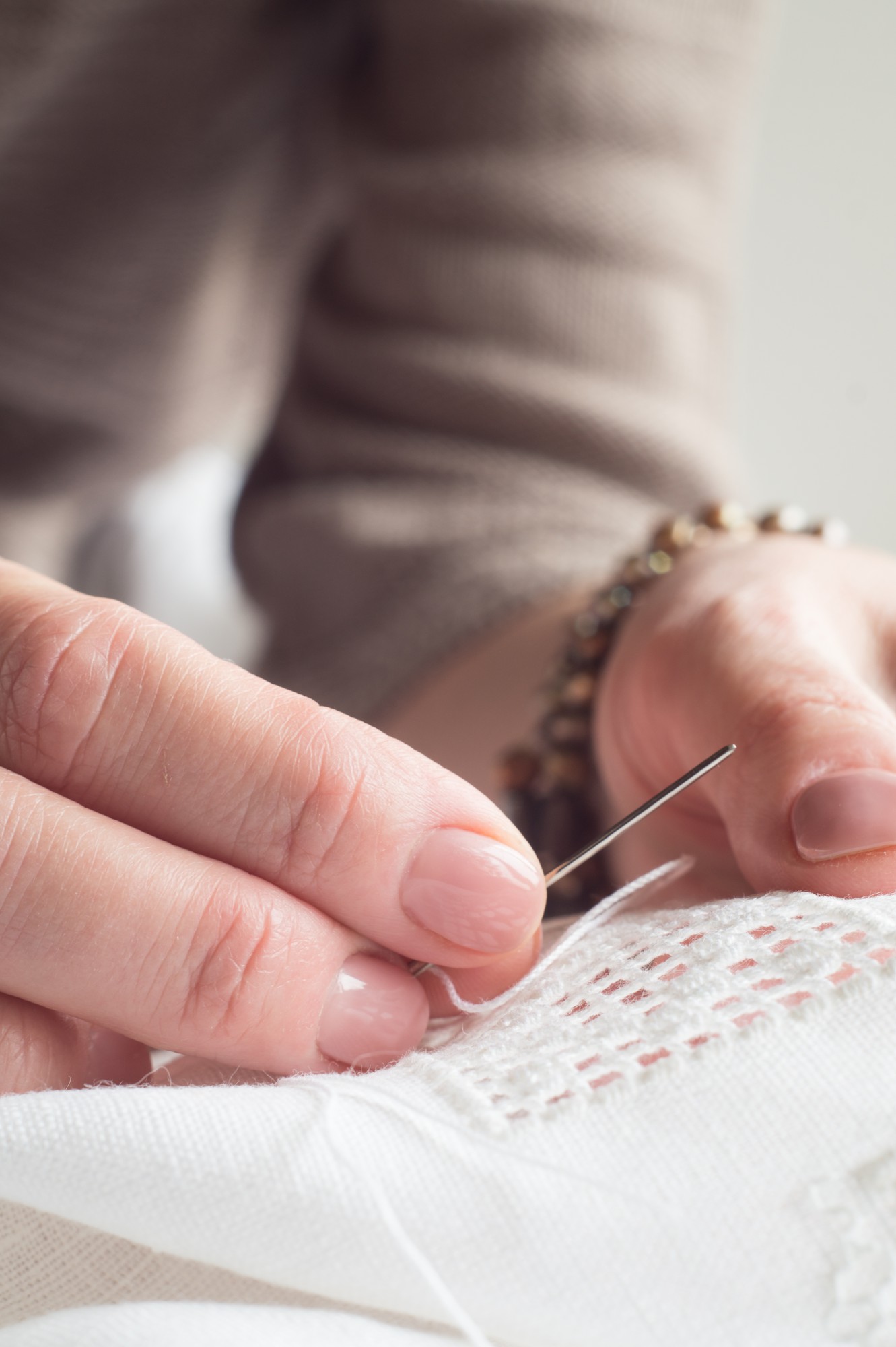 close-up of hand stitching on linen with warm threads